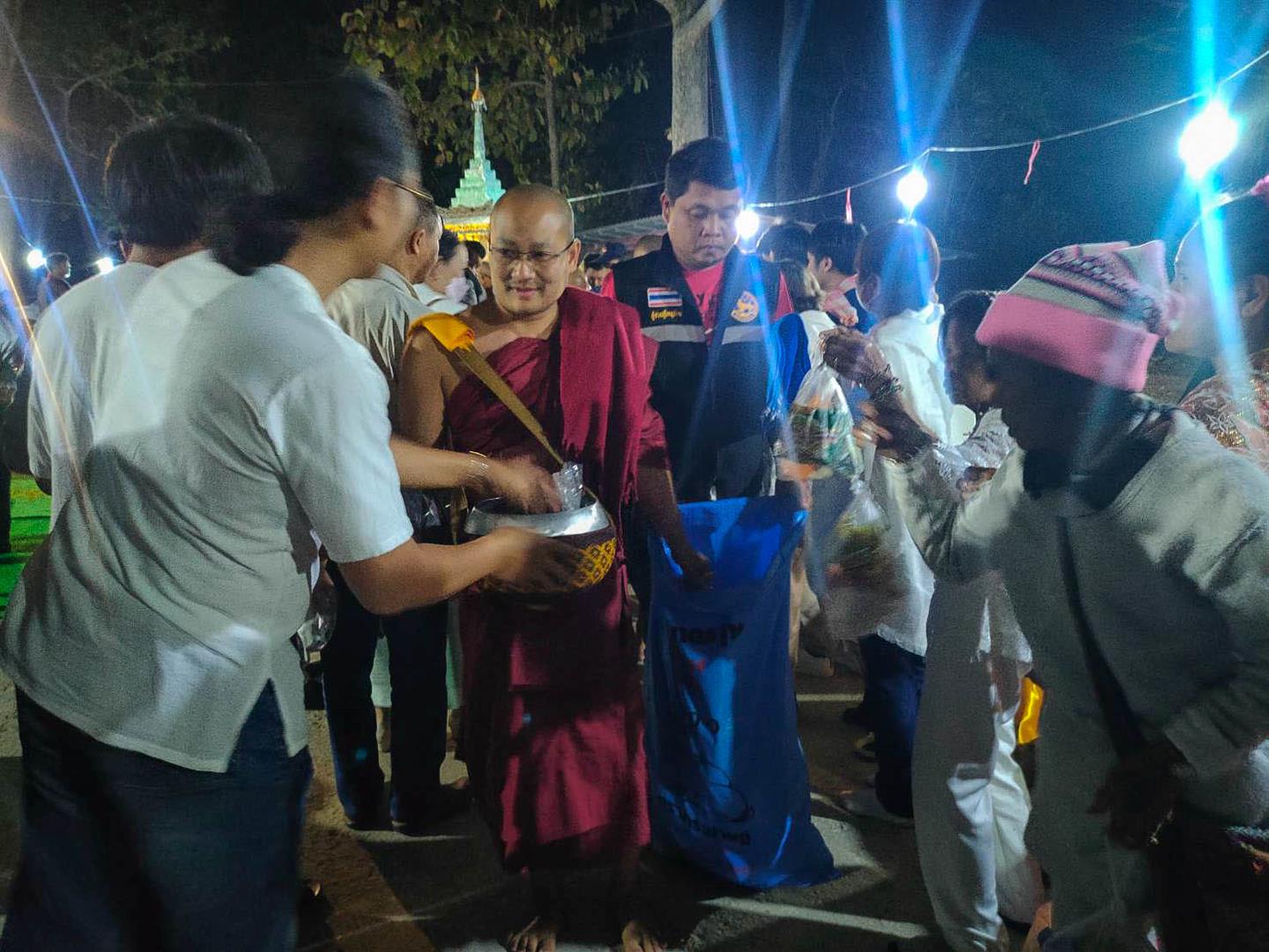 Community members giving alms during the Peng Pud Midnight Alms Walking Ceremony 2025