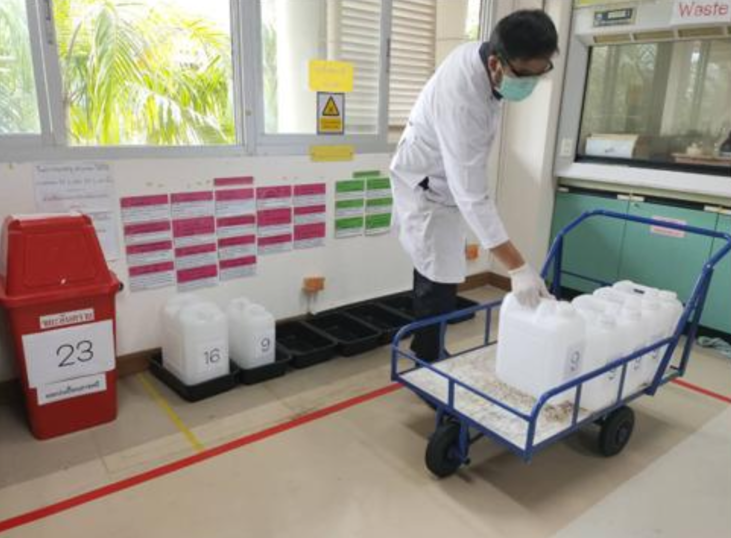 Staff transporting hazardous waste containers