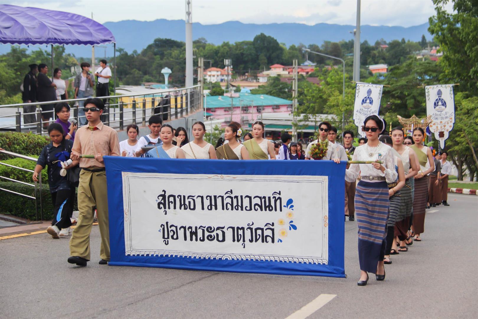 Students in traditional dress carrying decorative offerings during the walking into university activity 2025